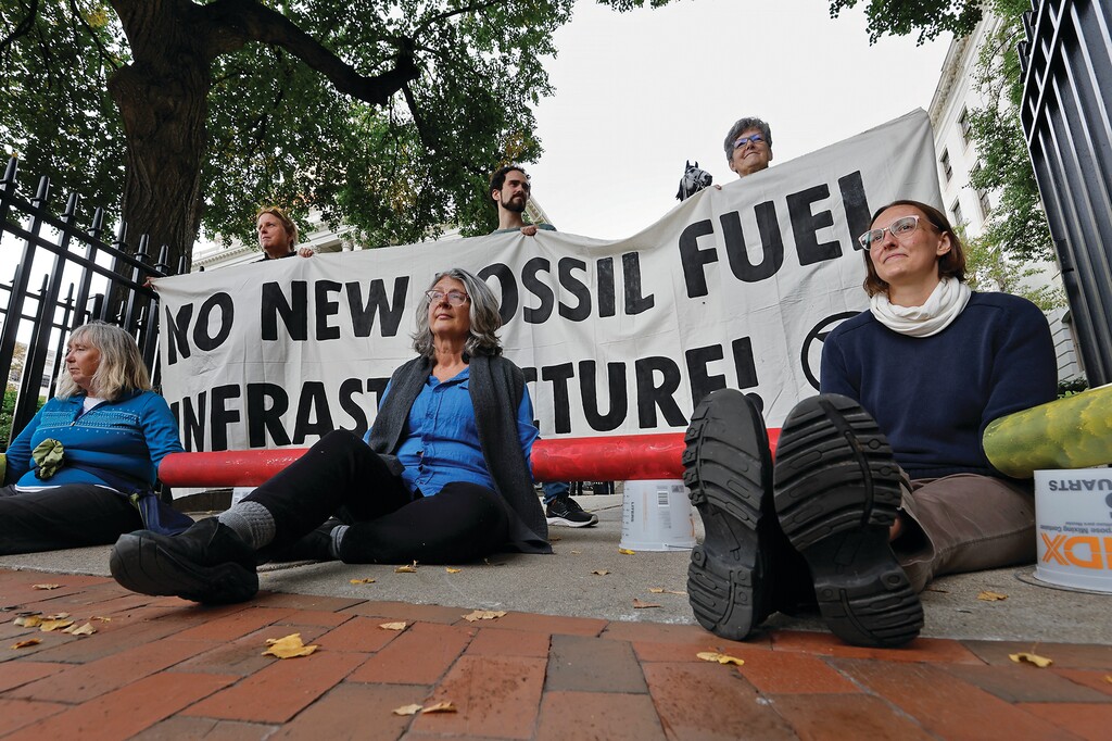 Climate activists from Extinction Rebellion lock themselves to the fence at the entance to the Massachusetts Statehouse during a protest against new fossil fuel infrastructure, Monday, Sept. 23, 2024, in Boston. (AP Photo/Michael Dwyer)