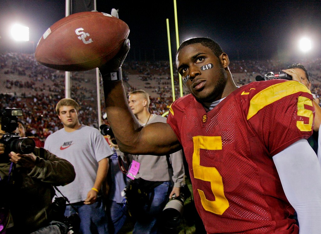 (Kevork Djansezian | AP) In this Nov. 19, 2005, file photo, Southern California tail back Reggie Bush walks off the field holding the game ball after the Trojans defeated Fresno State, 50-42, at the Los Angeles Coliseum. The former star running back had been prohibited from interacting in an official capacity with the school he played for from 2003-05 since NCAA sanctions handed down in 2010. Bush and USC were penalized for him and his family receiving impermissible benefits while he was still in school. USC President Carol Folt wrote in a letter to Bush on Wednesday, June 10, 2020, that he could now “be afforded the privileges and courtesies extended to all Trojan football alums.”
