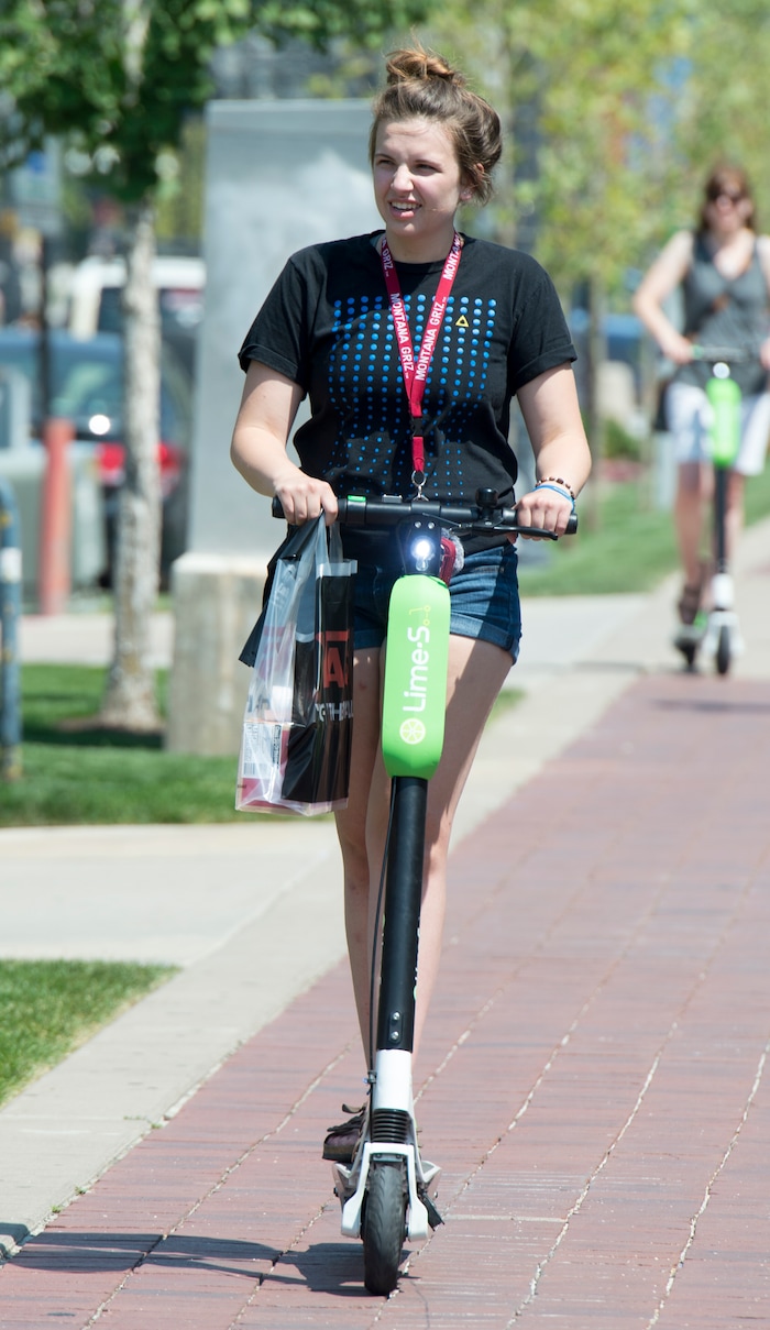 (Rick Egan  |  The Salt Lake Tribune)    Becca Emter, from Helena Montana, rides a Lime Scooter South Temple, in Salt Lake City, Monday, July 30, 2018.

 
