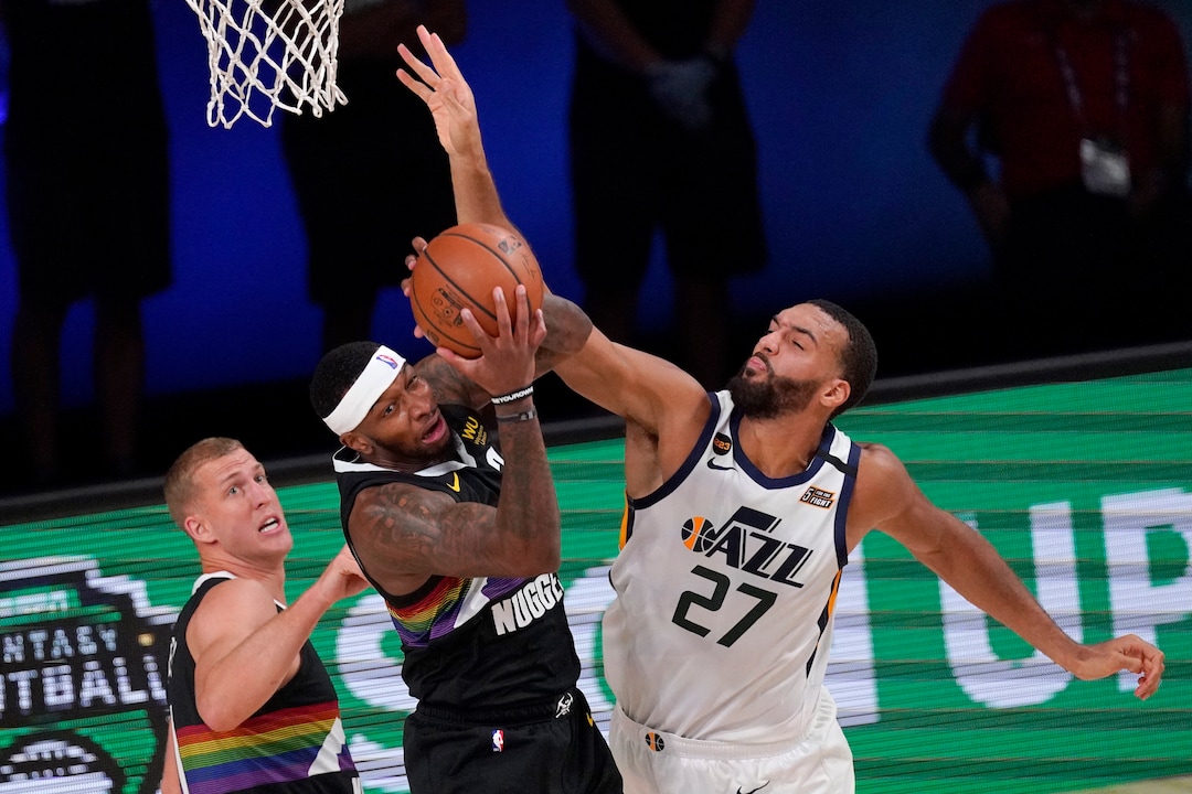 Denver Nuggets' Mason Plumlee, left, looks on as Torrey Craig, center, comes down with a rebound in front o Utah Jazz's Rudy Gobert (27) during the first half an NBA first round playoff basketball game, Tuesday, Sept. 1,2020, in Lake Buena Vista, Fla. (AP Photo/Mark J. Terrill)