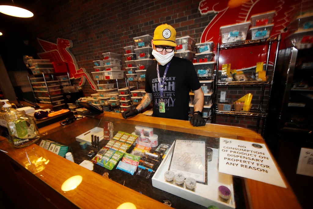 (David Zalubowski | AP) Ben Prater checks over his stock at his marijuana dispensary as a statewide stay-at-home order remains in effect in an effort to reduce the spread of the new coronavirus in Denver, Wednesday, April 8, 2020. The new coronavirus causes mild or moderate symptoms for most people, but for some, especially older adults and people with existing health problems, it can cause more severe illness or death.