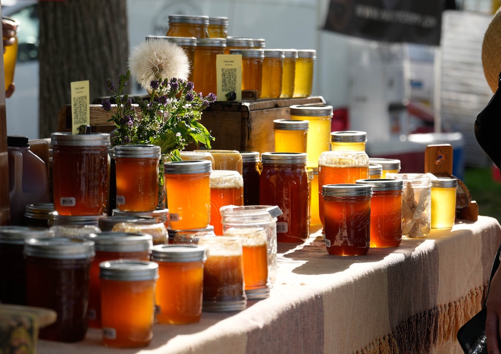 (Francisco Kjolseth |The Salt Lake Tribune) The early morning sun lights up honey from White Lake Farms at the Downtown Farmer's Market in Salt Lake City on Saturday, June 7, 2025. The market's winter season starts again on Nov. 15, 2025, and runs through April 2026.