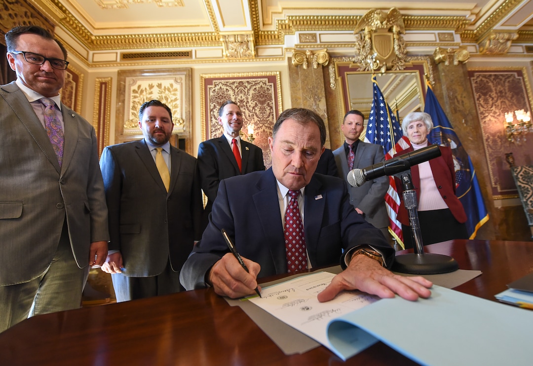 (Francisco Kjolseth  |  The Salt Lake Tribune)  Gov. Gary Herbert is surrounded by state representatives in the Gold Room of the Utah Capitol on Tuesday, March 27, 2018, as he sign H.B. 472 - Medicaid Expansion Revisions, which would expand Medicaid healthcare coverage to cover an additional 60,000 Utahns below the poverty line — pending approval from the federal government.