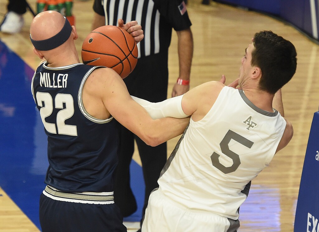 Utah State's Brock Miller and Air Force's Chris Joyce fight for the ball during the first half of the Aggies' 83-48 victory on Thursday, Dec. 31, 2020, at Air Force Academy, Colo. The teams met again on Saturday, Jan. 2, 2021, with Miller scoring 13 points and the Aggies coming away with a 72-53 victory. (Jerilee Bennett/The Gazette via AP)