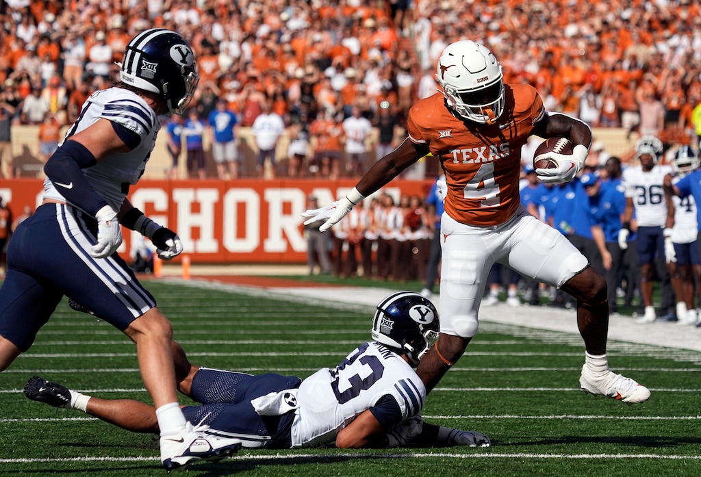 Texas running back CJ Baxter (4) tries to side step BYU safety Raider Damuni (33) during the first half of an NCAA college football game in Austin, Texas, Saturday, Oct. 28, 2023. (AP Photo/Eric Gay)