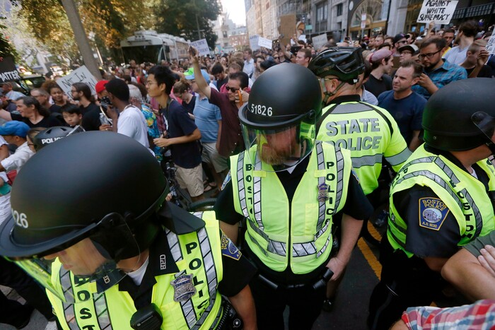 CORRECTS ACTIVITY OF POLICE TO PROVIDING EXIT LANE - State and local police stand amid counterprotesters to provide a lane for organizers to leave Boston Common where a "Free Speech" rally organized by conservative activists had been staged, Saturday, Aug. 19, 2017, in Boston.  (AP Photo/Michael Dwyer)