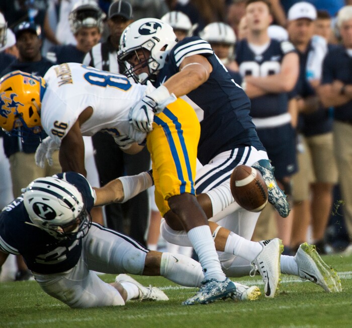 (Rick Egan  |  The Salt Lake Tribune)    Brigham Young Cougars defensive back Austin Kafentzis (24) and linebacker Nate Sampson (50), force a fumble as they hit McNeese State Cowboys wide receiver Rodnell Cruell (86), in football action Brigham Young Cougars vs McNeese State Cowboys at Lavell Edwards Stadium, Saturday, Sept. 22, 2018.


