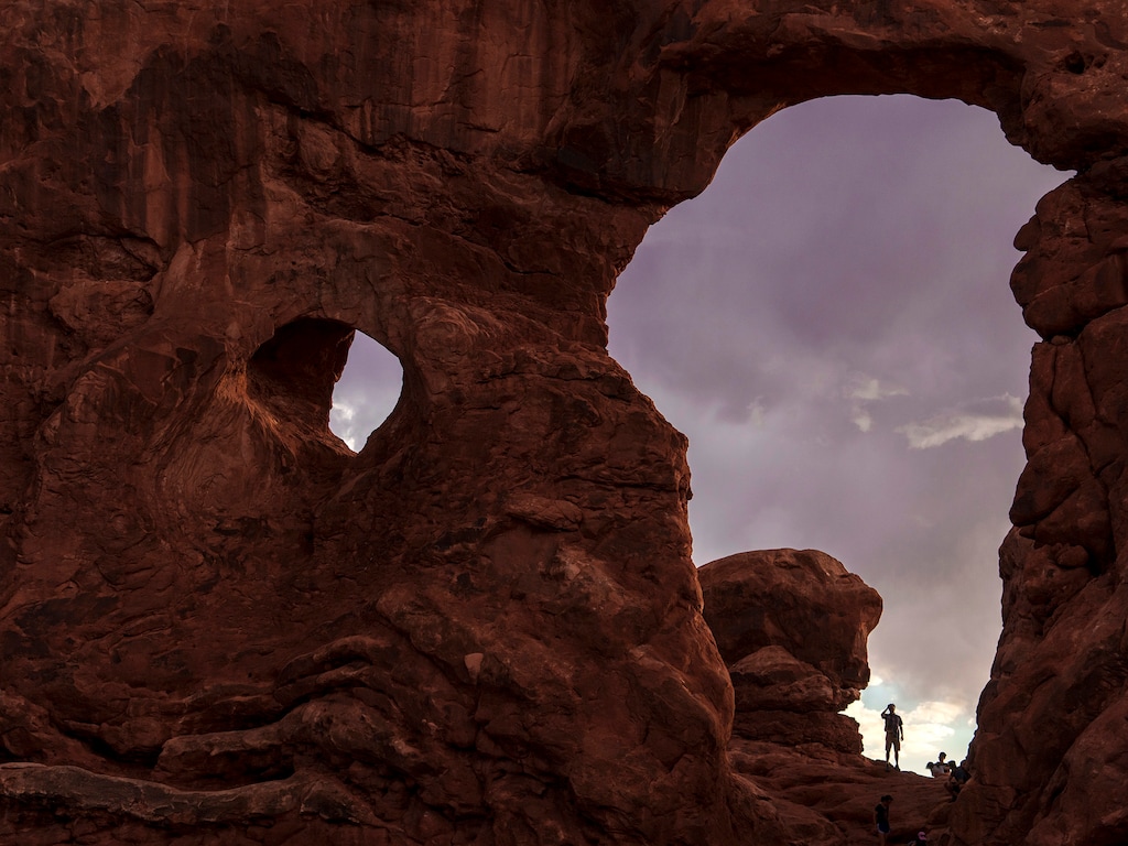(Leah Hogsten | The Salt Lake Tribune)  Visitors climb through Turret Arch in Arches National Park, Monday, May 15, 2023.