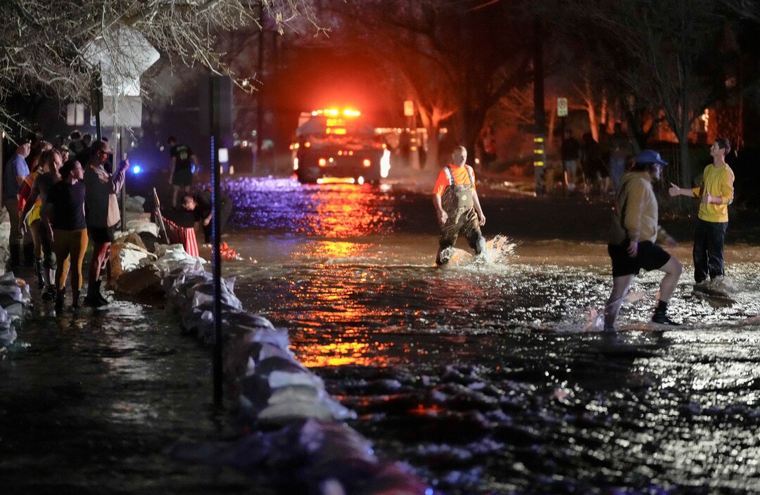 (Francisco Kjolseth | The Salt Lake Tribune) People work to protect homes into the night along 1700 South in Salt Lake City from the rising flow of Emigration Creek through Wasatch Hollow Park on Wednesday, April 12, 2023. 