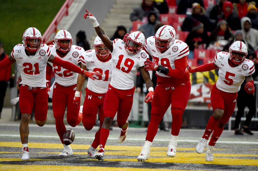 FILE - In this Saturday, Nov. 23, 2019, file photo, Nebraska safety Marquel Dismuke (19) celebrates with teammates after recovering a fumble from Maryland running back Javon Leake (20) during the first half of an NCAA college football game against Maryland, in College Park, Md. Nebraska's 24-sport program has about 600 athletes and is one of a handful that makes money. Though a 10% budget cut was announced recently, the program is able to absorb the cost of coronavirus testing, in part because of its affiliation with the university’s medical school.(AP Photo/Will Newton, File)