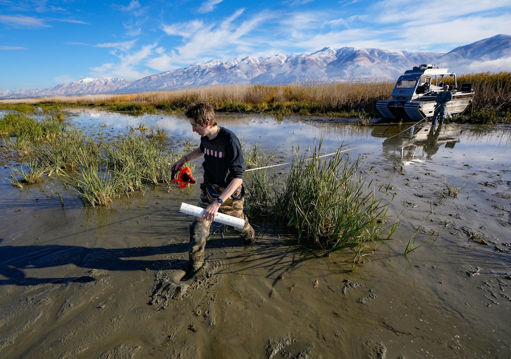 (Francisco Kjolseth | The Salt Lake Tribune) U. of U. graduate geoscience groundwater hydrology student Alex Engstrom, measures out a line of groundwater monitoring devices across a widened discharge channel for the central Davis sewer plant near Farmington Bay on Thursday, Nov. 3, 2022. Engstrom is in the process of measuring groundwater seepage that originates from a number of sources nearby with a primary look at levels of mercury.