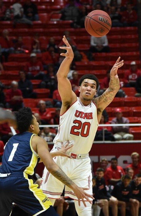 (Francisco Kjolseth | The Salt Lake Tribune) Utah Utes forward Timmy Allen (20) fins an opening past Northern Arizona Lumberjacks guard Davon Bolton (1) during a game at the Huntsman Center in December. Behind him: a sea of empty seats. The Utes, like many other men's college basketball teams, are struggling with attendance declines.