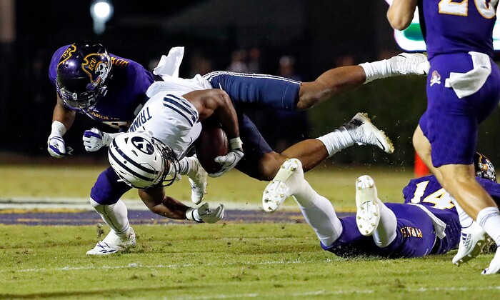 BYU's Jonah Trinnaman (3) is upended by East Carolina's Travis Phillips (14) and collides with Hussein Howe (28) during the second half of an NCAA college football game in Greenville, N.C., Saturday, Oct. 21, 2017. (AP Photo/Karl B DeBlaker)