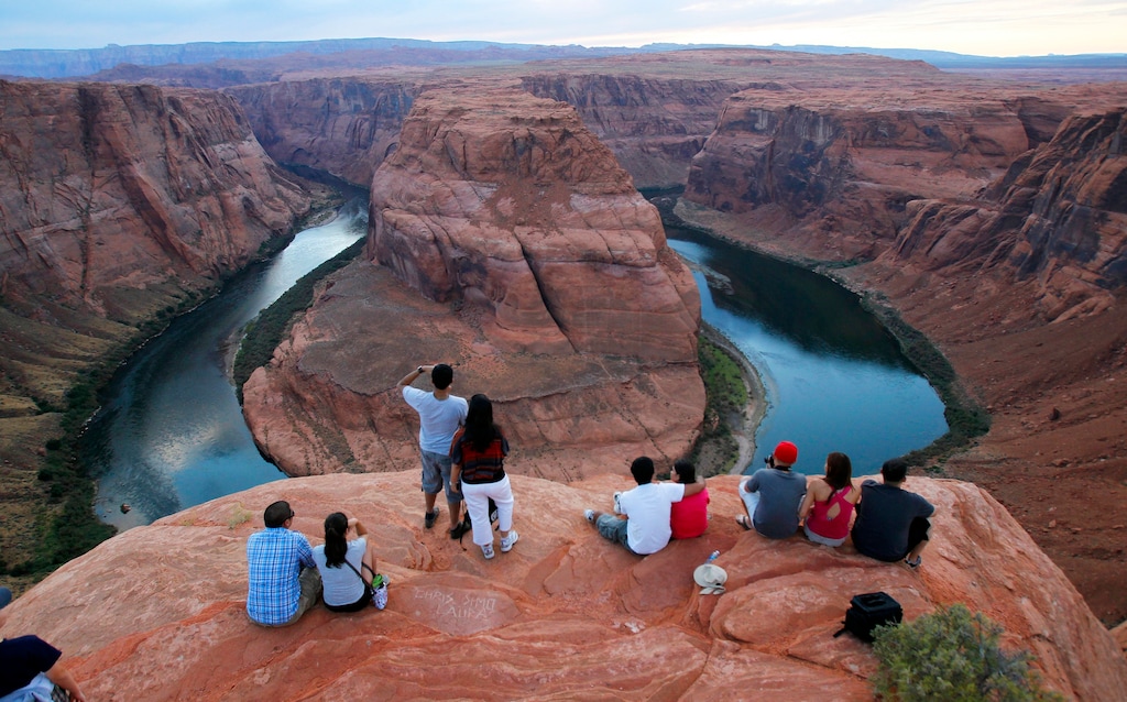 (Ross D. Franklin | AP) Visitors view the dramatic bend in the Colorado River at the popular Horseshoe Bend in Glen Canyon National Recreation Area, in Page, Ariz., Sept. 9, 2011. Grand Canyon National Park officials tentatively plan to reopen the park's eastern entrance in late May 2021, but there's sentiment in the small northern Arizona city that depends on tourism that sooner would be better. “Our sales tax for this year is down nearly 30% from last year," Page city manager Darren Coldwell told the Arizona Daily Sun. “Our Horseshoe Bend visitation is down 80%. So when we say that our numbers dropped off the face of the earth, they really did.”