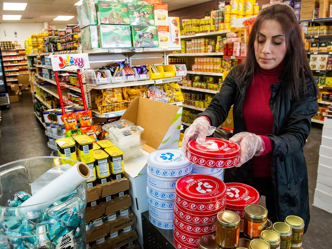 (Rick Egan  |  The Salt Lake Tribune)    Leila Sabat straightens food on the shelves of the Specialty Market in Midvale, which is suffering from the effects of COVID-19  Wednesday, March 25, 2020.