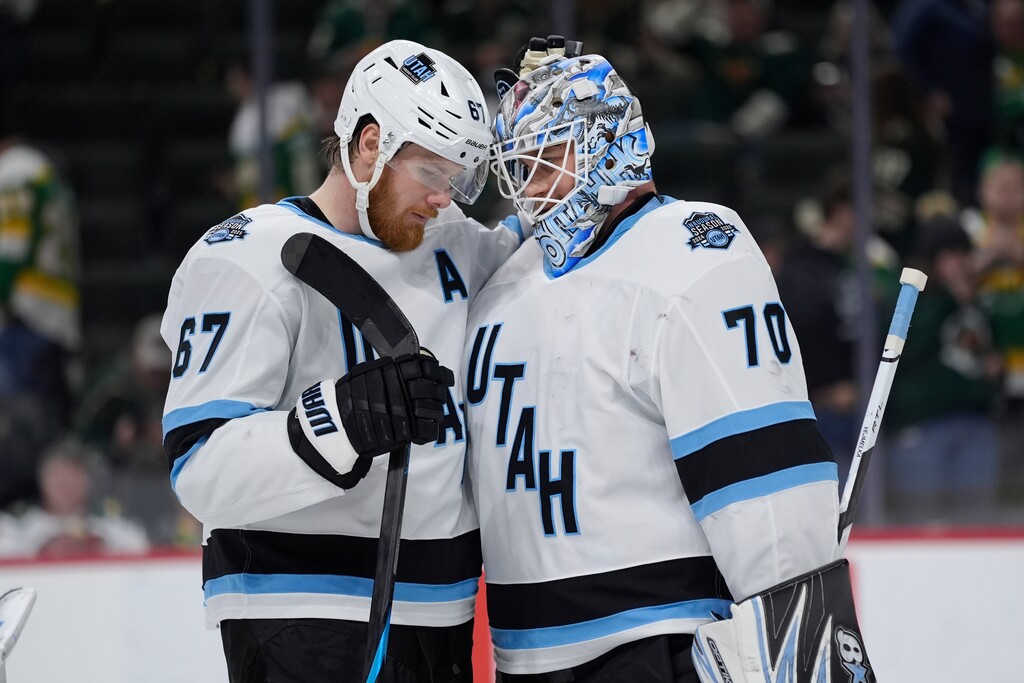 Utah Hockey Club left wing Lawson Crouse (67) and goaltender Karel Vejmelka (70) hug after a win over the Minnesota Wild of an NHL hockey game, Thursday, Jan. 23, 2025, in St. Paul, Minn. (AP Photo/Abbie Parr)