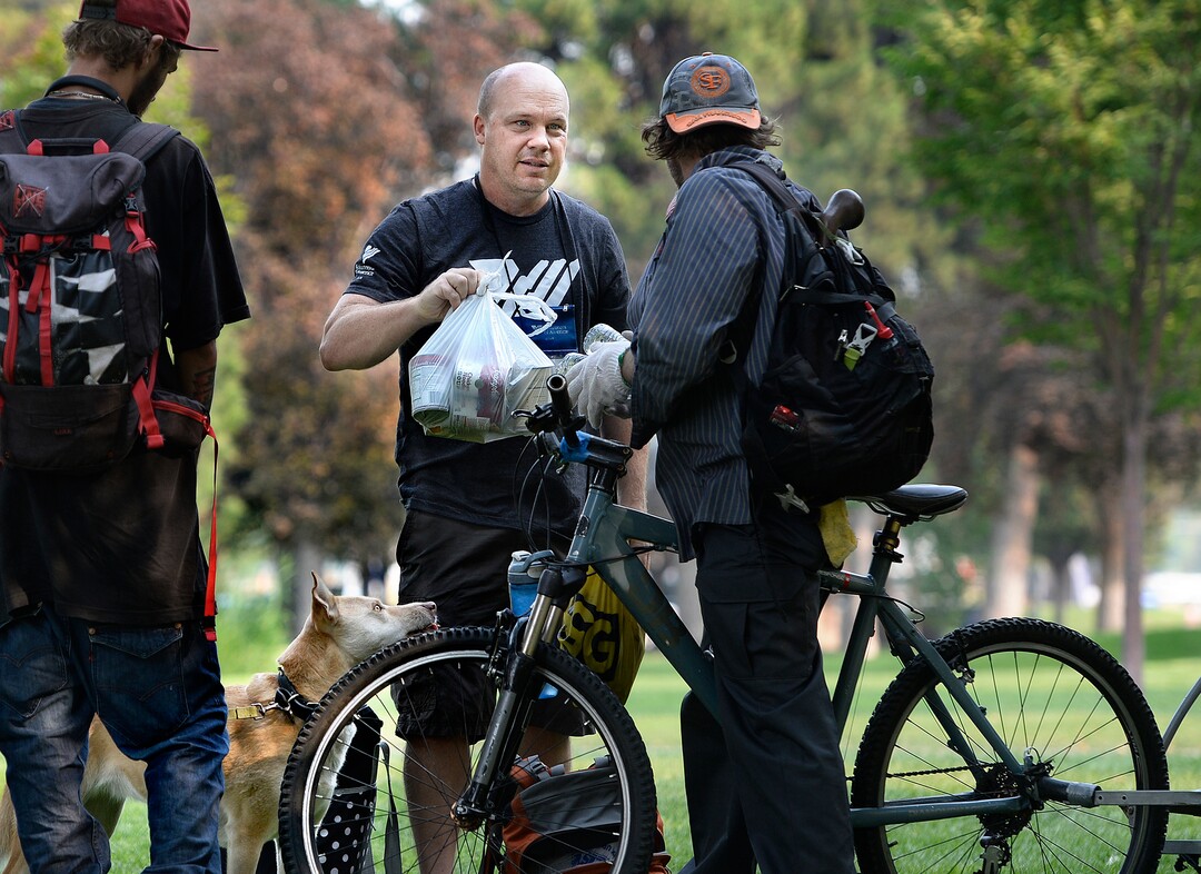(Scott Sommerdorf   |  The Salt Lake Tribune)   Sean Spalding, of the Volunteers of America, hands out some supplies to homeless men in Fairmont Park, Wednesday, September 6, 2017.