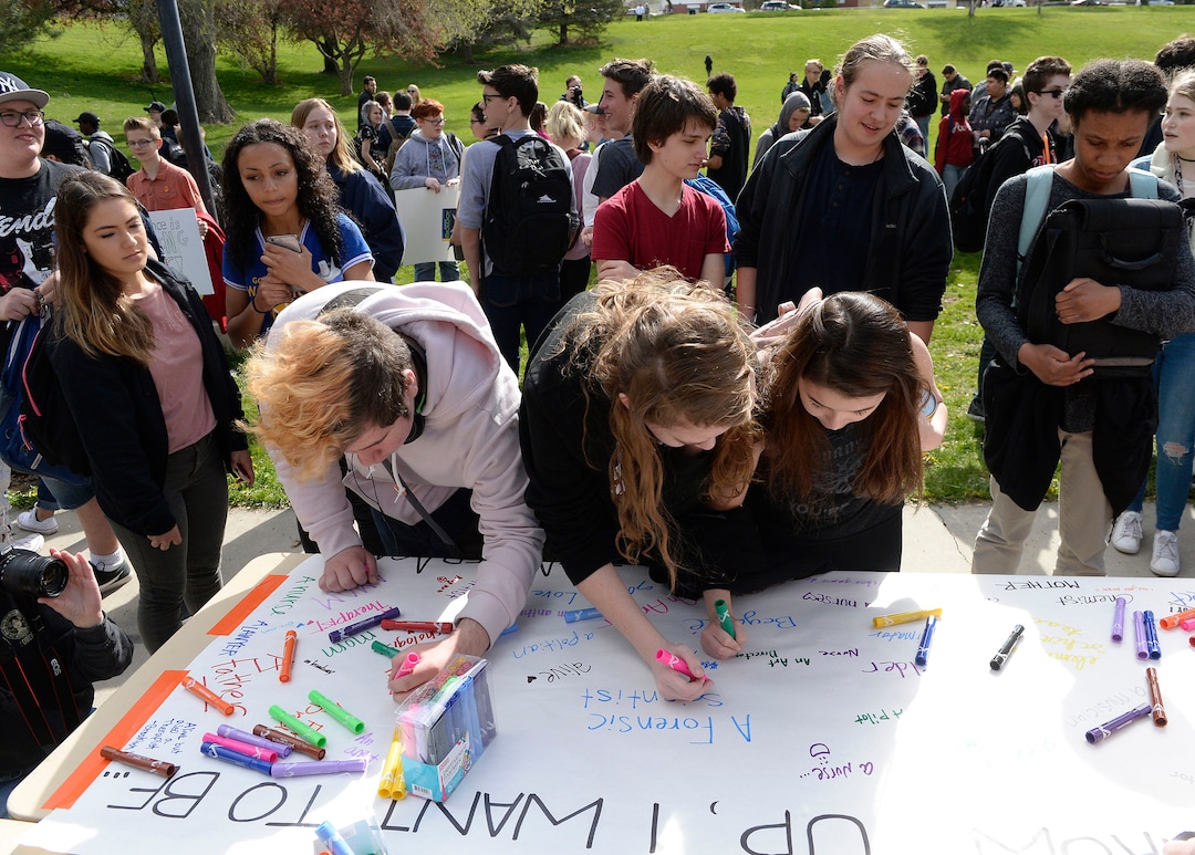 (Al Hartmann  |  The Salt Lake Tribune) 	Highland High School students sign a poster that said "When I grow up I want to be...."  Over one hundred students at Highland High School staged a walkout Friday April 20, 2018 in honor of the anniversary of the Columbine High School massacre. Demonstrators walked from the school to Sugar House Park where they made posters, wrote letters to their congressmen and listened to speakers. 