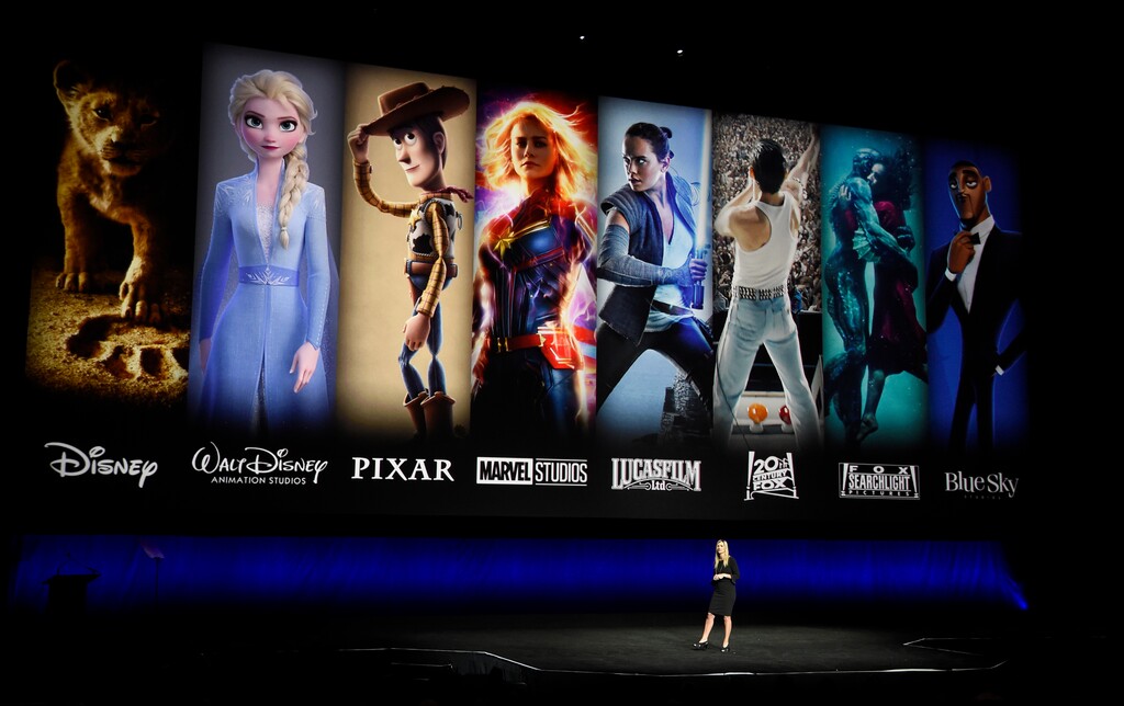 (Chris Pizzello | Invision/AP, file) In this April 3, 2019, file photo, characters from Disney and Fox movies are displayed behind Cathleen Taff, president of distribution, franchise management, business and audience insight for Walt Disney Studios during the Walt Disney Studios Motion Pictures presentation at CinemaCon 2019, the official convention of the National Association of Theatre Owners (NATO) at Caesars Palace in Las Vegas. On Tuesday, Nov. 12, Disney Plus launched its streaming service.
