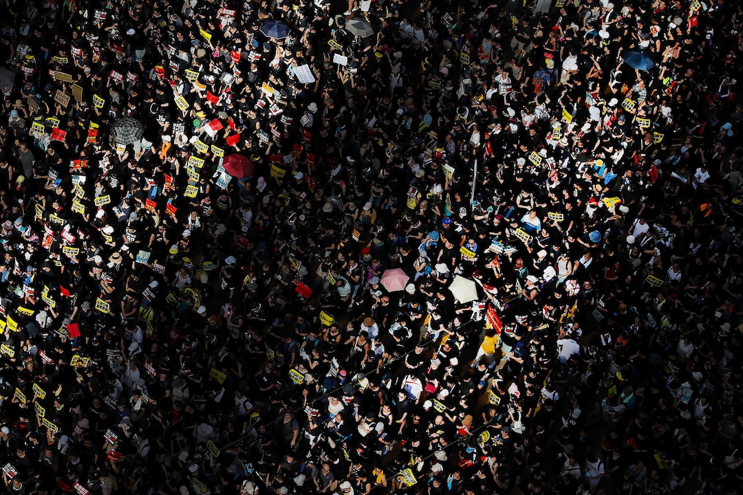 (Kin Cheung | AP Photo) Beams of sunlight are cast on protesters as they march during a rally in Hong Kong, Monday, July 1, 2019. Combative protesters tried to break into the Hong Kong legislature Monday as a crowd of thousands prepared to start a march in that direction on the 22nd anniversary of the former British colony's return to China.