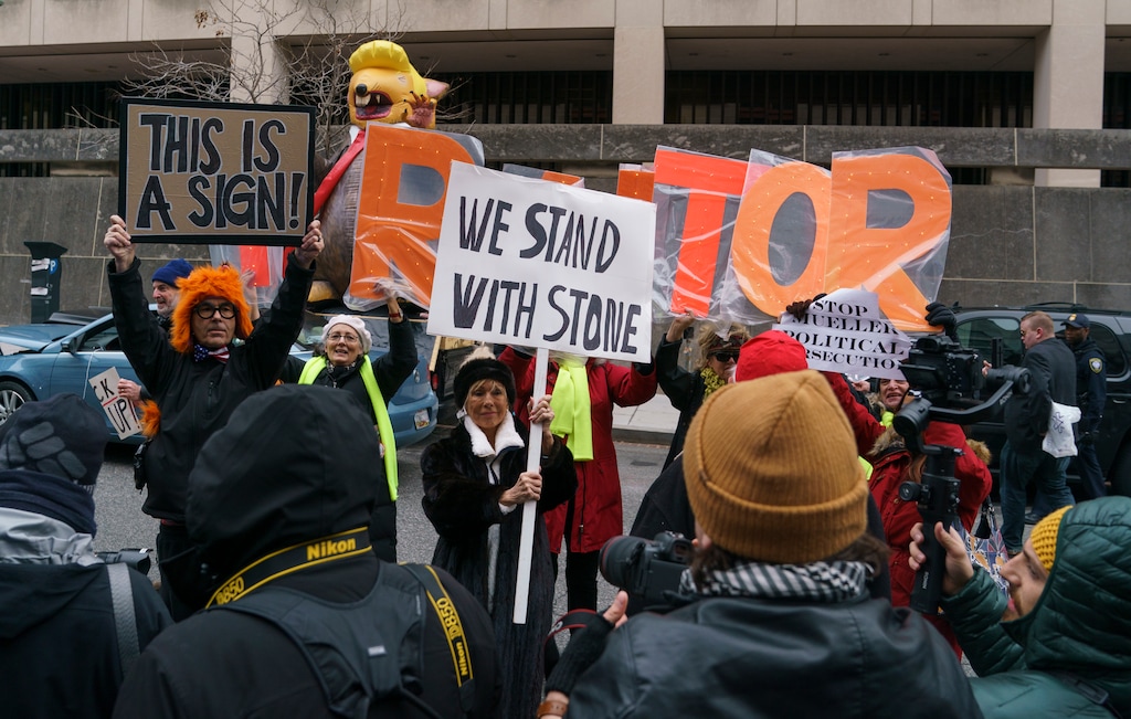 People gather to show support and protest former campaign adviser for President Donald Trump, Roger Stone, after he departed federal court in Washington, Tuesday, Jan. 29, 2019. Stone left the federal courthouse without speaking publicly after entering a not guilty plea to charges filed in the special counsel's Russia investigation. (AP Photo/Carolyn Kaster)