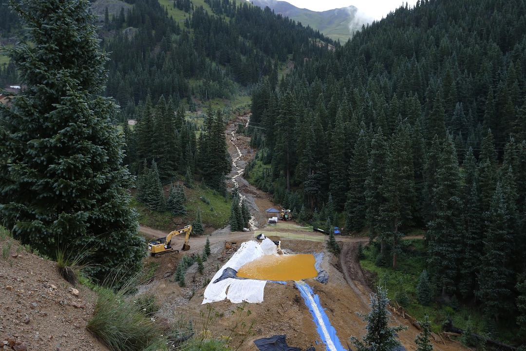 Water flows through one in a series of retention ponds built to contain and filter out heavy metals and chemicals from the Gold King mine wastewater accident, in the spillway about 1/4 mile downstream from the mine, outside Silverton, Colo., Wednesday, Aug. 12, 2015. The Environmental Protection Agency has taken full responsibility for the mine waste spoiling rivers downstream from Silverton, but people who live near the idled and leaking Gold King mine say local authorities and mining companies spent decades spurning federal cleanup help. (AP Photo/Brennan Linsley)