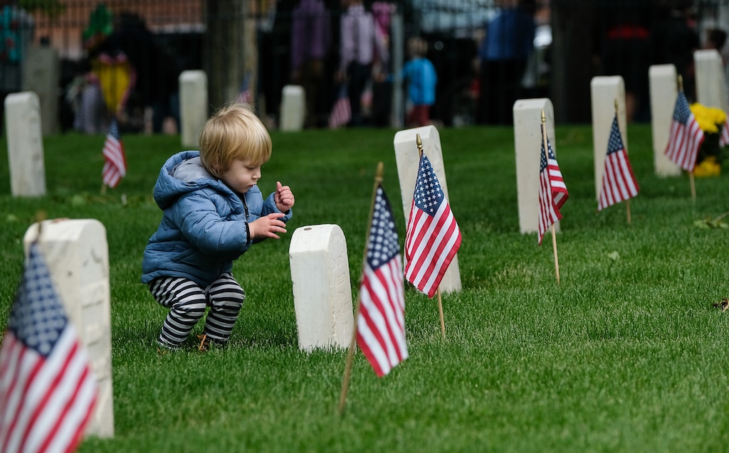 (Francisco Kjolseth  |  The Salt Lake Tribune)  Leo Wilson participates in the tradition of placing a penny on top of military grave stones as the Association of the United States Army's Utah Chapter hosts a Memorial Day ceremony at Fort Douglas Cemetery on May 27.
