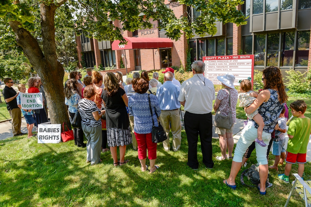 Leah Hogsten  |  The Salt Lake Tribune   Catholic priest, Rev. Jan Bednarz of St. Martin de Porres Parish in Taylorsville, leads the "blessed sacrament" and exorcism at the Planned Parenthood offices on the Feast of the Assumption. Bednarz was joined by the group, "40 Days for Life Utah," to protest Planned Parenthood. 