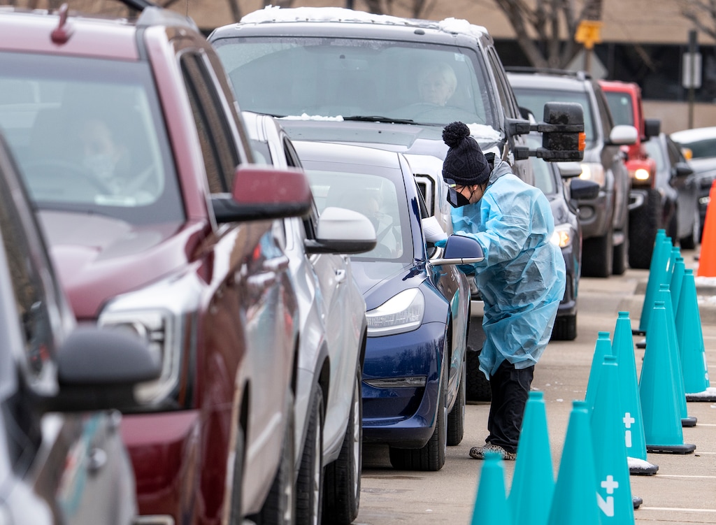 (Leah Hogsten | The Salt Lake Tribune) A steady line of vehicles filled with multiple people waiting to be tested for Covid19 are tended to by members of the Utah Department of Health at the Cannon Health Building, Dec. 27, 2021. 