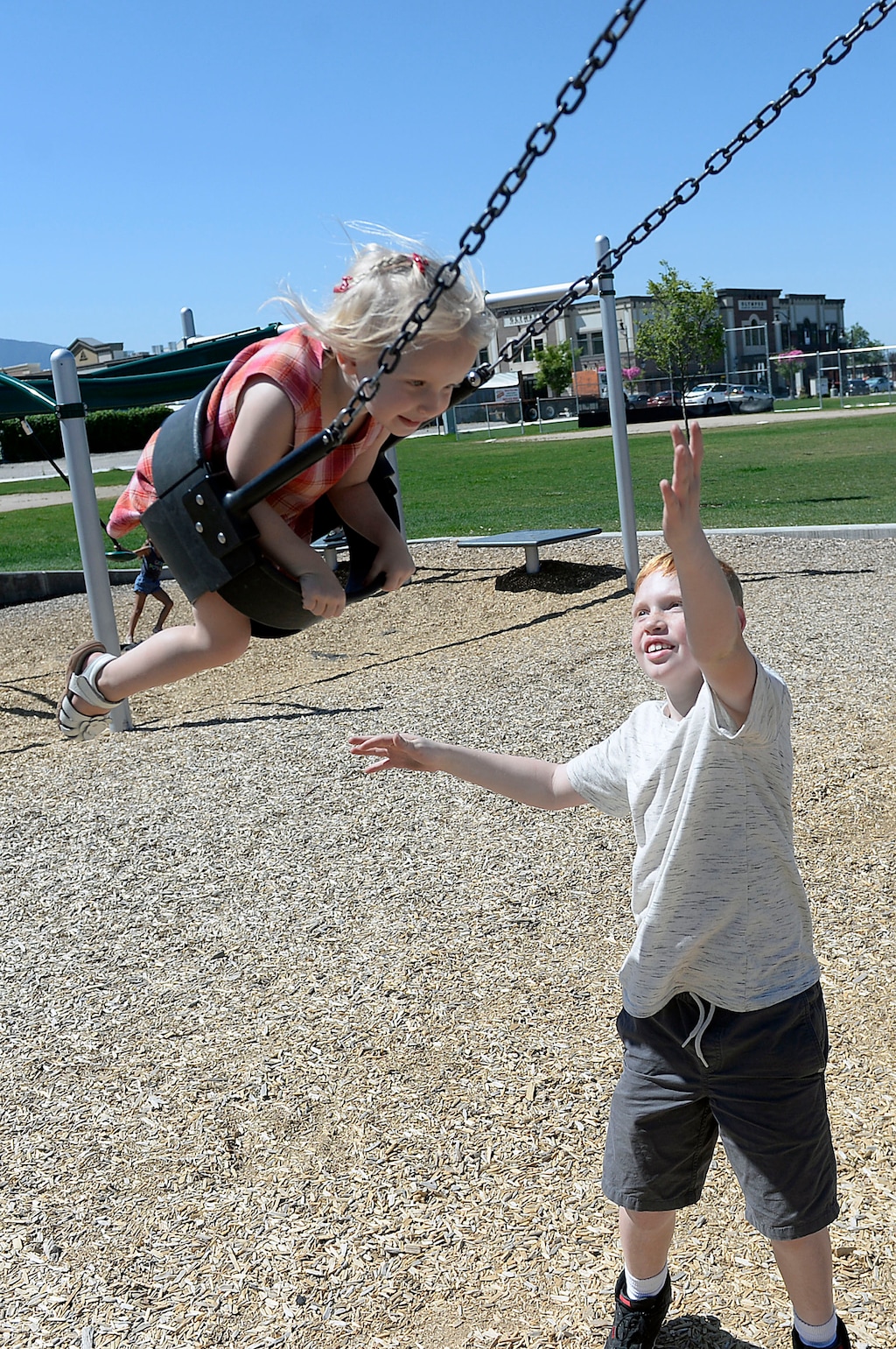 Al Hartmann  |  The Salt Lake TribuneJack Derum, 10, pushes his little sister Margot, almost 3 at the Holladay Library Thursday June 22.   Time at the park in the morning before heat sets is part of "staycation" during the Summer.
