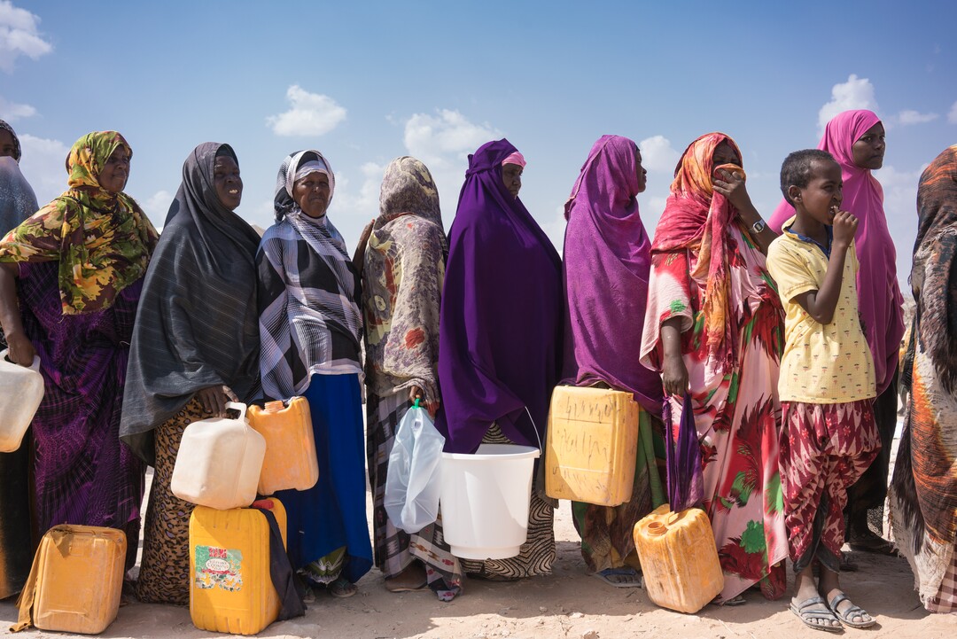 (© UNICEF/UN061108/Knowles-Cours; Couresty LDS Church) Displaced women queue with containers for clean water from a UNICEF and ECHO-supported clean-water tank at the internally displaced peoples camp in Galkayo, Somalia, Wednesday 12 April 2017. Over 500,000 people in Somalia have been forced to leave their homes in search of food and water.
