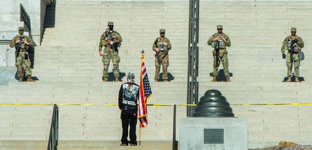 (Rick Egan | The Salt Lake Tribune) Martin Turner stands with an upside down flag was one of a dozen protesters showed up at the Utah Capitol, on Sunday, Jan. 17, 2021.