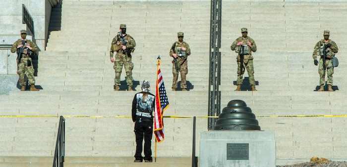 (Rick Egan | The Salt Lake Tribune) Martin Turner stands with an upside down flag was one of a dozen protesters showed up at the Utah Capitol, on Sunday, Jan. 17, 2021.