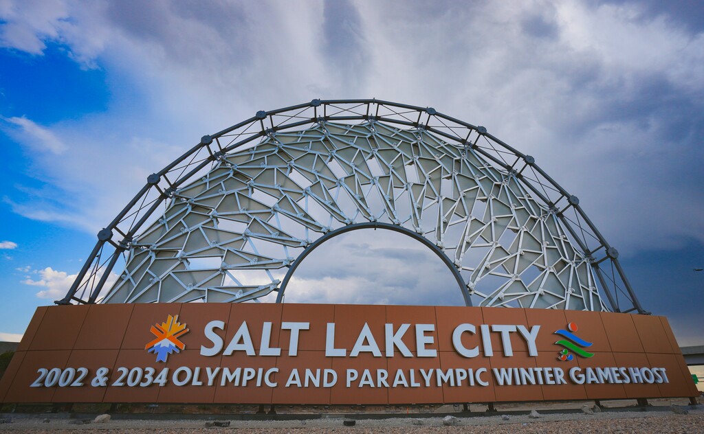 (Bethany Baker | The Salt Lake Tribune) A sign celebrates both the 2002 Olympic Games and the upcoming 2034 Olympic Games in Salt Lake City at the Salt Lake City International Airport on Monday, Sept. 9, 2024.
