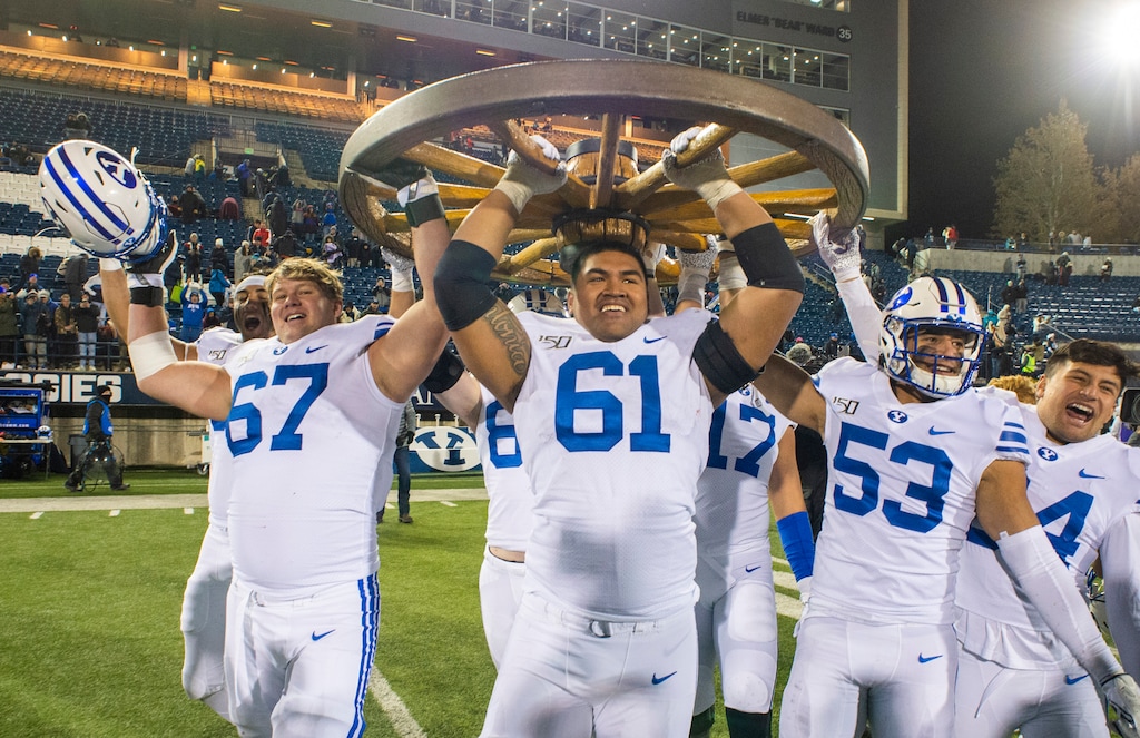(Rick Egan  |  The Salt Lake Tribune)       The Brigham Young Cougars celebrate their win over the Aggies as they carry the Old Wagon Wheel, after defeating Utah State 42-14, in football action between Brigham Young Cougars and Utah State Aggies in Logan, Saturday, Nov. 2, 2019.