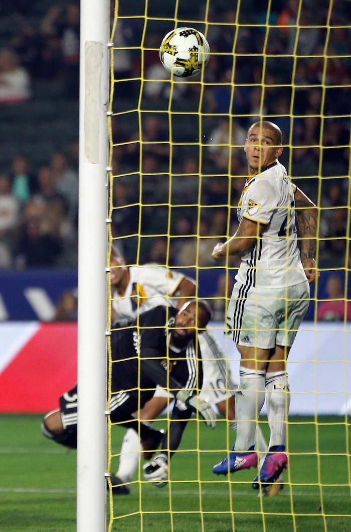 Los Angeles Galaxy midfielder Rafael Garcia, right, goalkeeper Clement Diop, center, and forward Giovani dos Santos (10) watch as Real Salt Lake midfielder Kyle Beckerman's ricochet shot go into the net during the second half of an MLS soccer game in Carson, Calif., Saturday, Sept. 30, 2017. They tied the game 1-1. (AP Photo/Alex Gallardo)