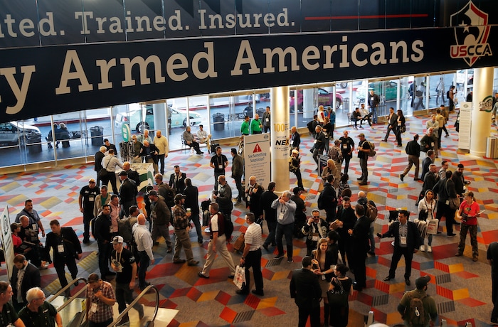 People walk through halls outside of the SHOT Show gun show Wednesday, Jan. 24, 2018, in Las Vegas. (AP Photo/John Locher)