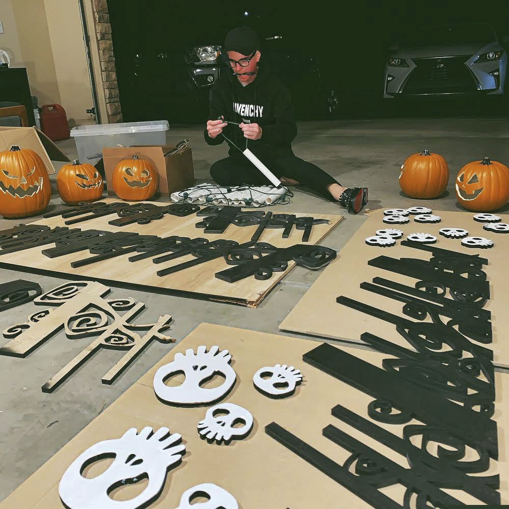 (Shane Stewart via AP) In this undated photo provided by Shane Stewart, Dixie State University professor Josh Pedersen works with PVC pipe and laser cut swirls to create intricate decorations for his roof, inspired by Disneyland's Haunted Mansion attraction in St. George, Utah. The college professor has completed a massive project decorating the exterior of his house in an elaborate Halloween tribute to Disneyland's Haunted Mansion and the "Nightmare Before Christmas." The Spectrum newspaper reports Pedersen studied more than 200 images of the attraction to model the design as close to the original as possible.