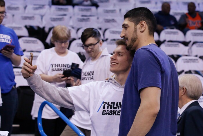 New York Knicks' Enes Kanter, right, a former Oklahoma City Thunder center, poses for a selfie with a fan before Game 5 of an NBA basketball first-round playoff series between the Utah Jazz and the Thunder in Oklahoma City, Wednesday, April 25, 2018. (AP Photo/Sue Ogrocki)