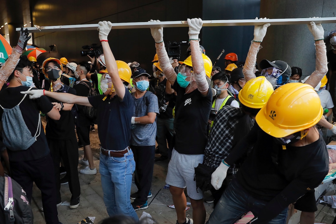 (Kin Cheung | AP Photo) Protesters remove a structure which they damaged from the Legislative Council in Hong Kong, Monday, July 1, 2019.  Combative protesters tried to break into the Hong Kong legislature Monday as a crowd of thousands prepared to start a march in that direction on the 22nd anniversary of the former British colony's return to China.