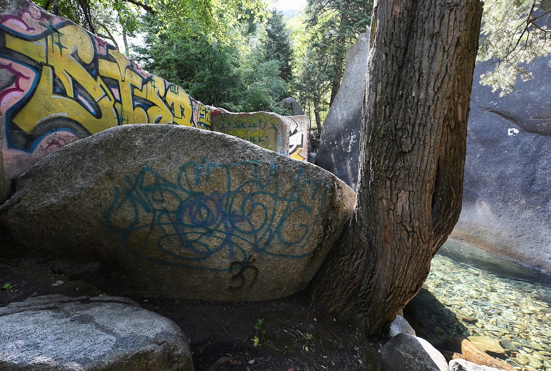(Francisco Kjolseth  |  The Salt Lake Tribune)  Graffiti has proliferated in lower Little Cottonwood Canyon, where vandals, often wielding cans of fluorescent-colored spray paint, have covered granite faces, trees and structures. The vandalism is particularly apparent along the Temple Quarry Trail and the creek at the Moon Rock swimming hole and former pavilion site. Volunteers using donated equipment and solvents spend thousands of hours removing the paint from the rocks only to see graffiti return to the same faces or on rock nearby.