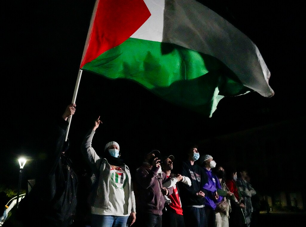 (Bethany Baker  |  The Salt Lake Tribune) A protester waves a Palestinian flag as law enforcement order them to disperse during the pro-Palestine rally at the University of Utah in Salt Lake City on Monday, April 29, 2024.