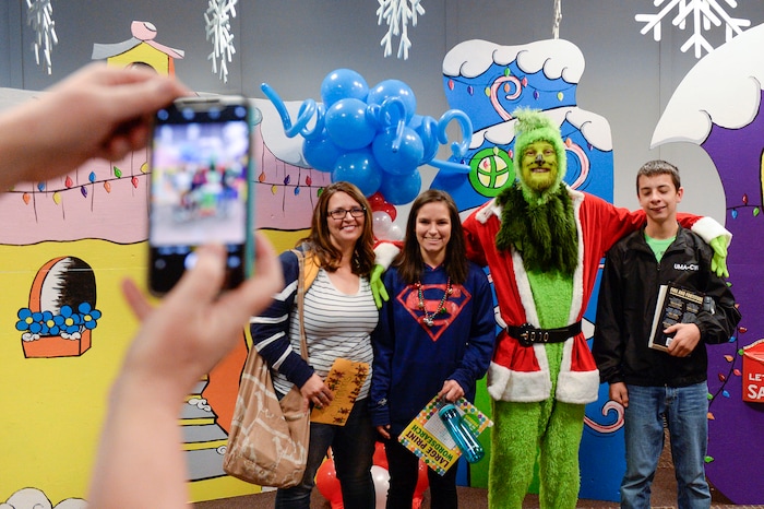 (Leah Hogsten | The Salt Lake Tribune) l-r Michelle Simmons, widow of Sgt. Matthew Simmons, poses with her daughter Ariana and son Eli with the Grinch on Saturday. Ten Gold Star families from Salt Lake City were treated to a Winter Wonderland scene, including Whoville and the Grinch at their boarding gate at Salt Lake International Airport, Dec. 7, 2019 before their flight to Disney World aboard the Snowball Express. This month, the Gary Sinise Foundation's Snowball Express will fly more than 1,700 family members of fallen U.S. military heroes to Disney World for a holiday retreat.