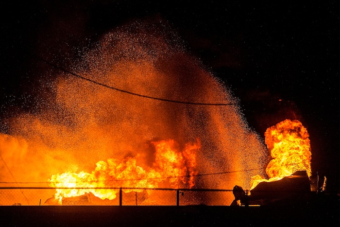 (Chris Detrick  |  The Salt Lake Tribune)  Firefighters attempt to put out a burning semitrailer that was hauling thousands of gallons of fuel on Interstate-15 in Midvale Thursday, January 18, 2018.   Lt. Todd Royce of the Utah Highway Patrol said the truck was southbound on the interstate at 7500 South at 7:20 p.m. when a tire caught fire, sending flames toward the tanks.