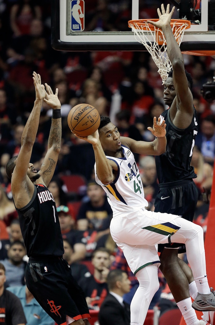 Utah Jazz guard Donovan Mitchell, center, passes the ball as Houston Rockets forward Trevor Ariza, left, and center Clint Capela defend during the first half in Game 5 of an NBA basketball second-round playoff series, Tuesday, May 8, 2018, in Houston. (AP Photo/Eric Christian Smith)
