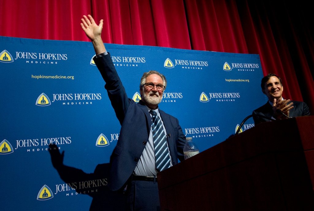 (Jose Luis Magana | AP) Professor Gregg Semenza, accompanied by Johns Hopkins University President Ron Daniels, waves to the crowd during a news conference after he was awarded the 2019 Nobel Prize in Medicine at Johns Hopkins Medicine Hospital in Baltimore, Md., Monday, Oct. 7, 2019. The 2019 Nobel Prize in Medicine has been jointly awarded to William Kaelin Jr., Sir Peter Ratcliffe and Gregg Semenza for their pioneering research into how human cells respond to changing oxygen levels.