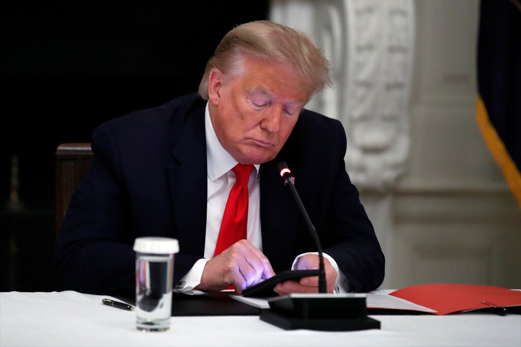 FILE - In this Thursday, June 18, 2020 file photo, President Donald Trump looks at his phone during a roundtable with governors on the reopening of America's small businesses, in the State Dining Room of the White House  in Washington. Though stripped of his Twitter account for inciting rebellion, President Donald Trump does have alternative options of much smaller reach. (AP Photo/Alex Brandon, File)