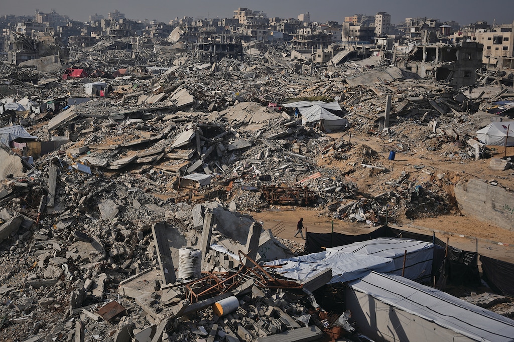 A man walks through the destruction caused by the Israeli air and ground offensive in Sheikh Radwan neighborhood in Gaza City, Friday, Nov. 28, 2025. (AP Photo/Abdel Kareem Hana)