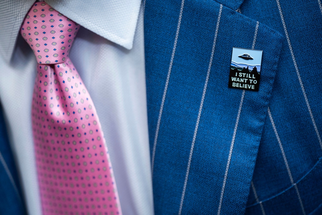 (Nathan Howard | AP) An audience member wears a UFO pin during a House Oversight and Accountability subcommittee hearing on UFOs, Wednesday, July 26, 2023, on Capitol Hill in Washington.