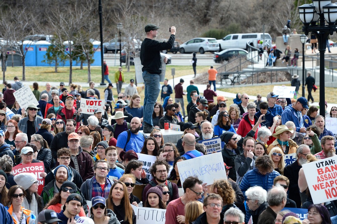 Scott Sommerdorf | The Salt Lake TribuneA man climbed op on a concrete abutment to photograph the huge crowd on the south lawn of the Utah State Capitol for the "For Our lives" rally, Saturday, March 24, 2018.